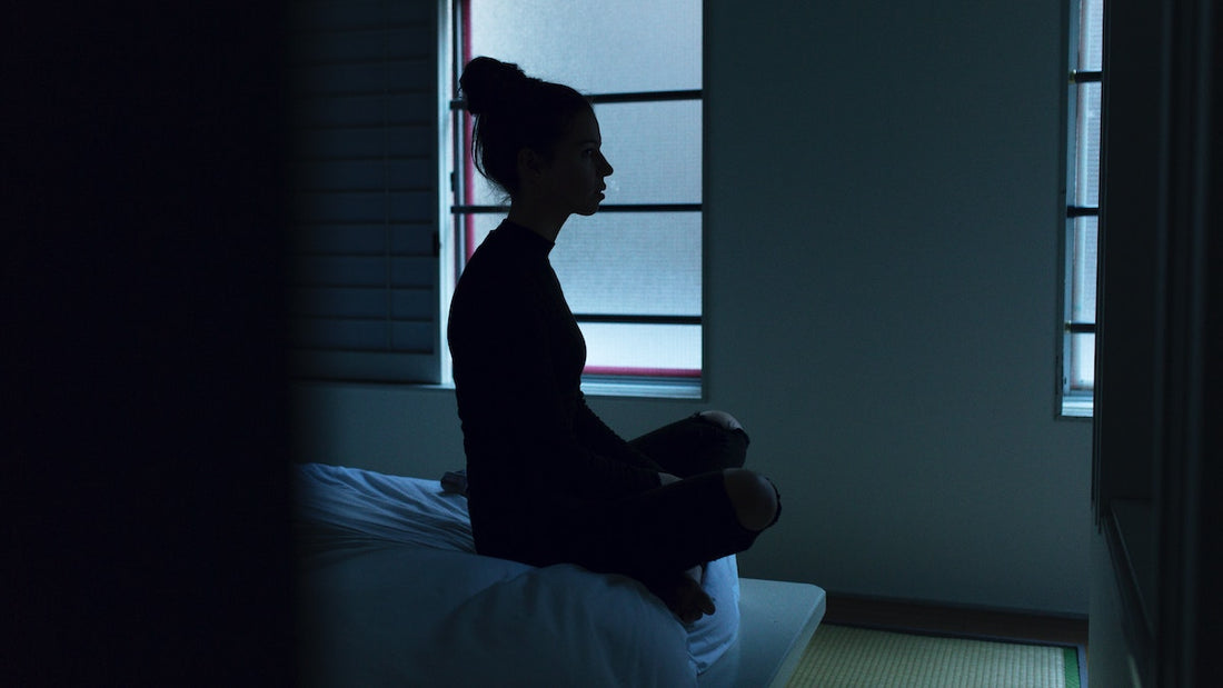 Frau die auf dem Bett sitzt und Depression hat